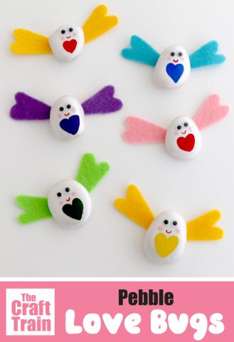 white painted rock with color hearts and felt colored wings