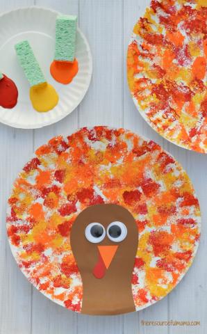 red, orange, yellow sponge paint with brown cardstock turkey and googly eyes on a paper plate