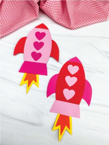 pink and red rocketship made of cardstock with hearts on the rocket