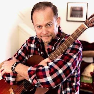 man in plaid shirt with guitar 